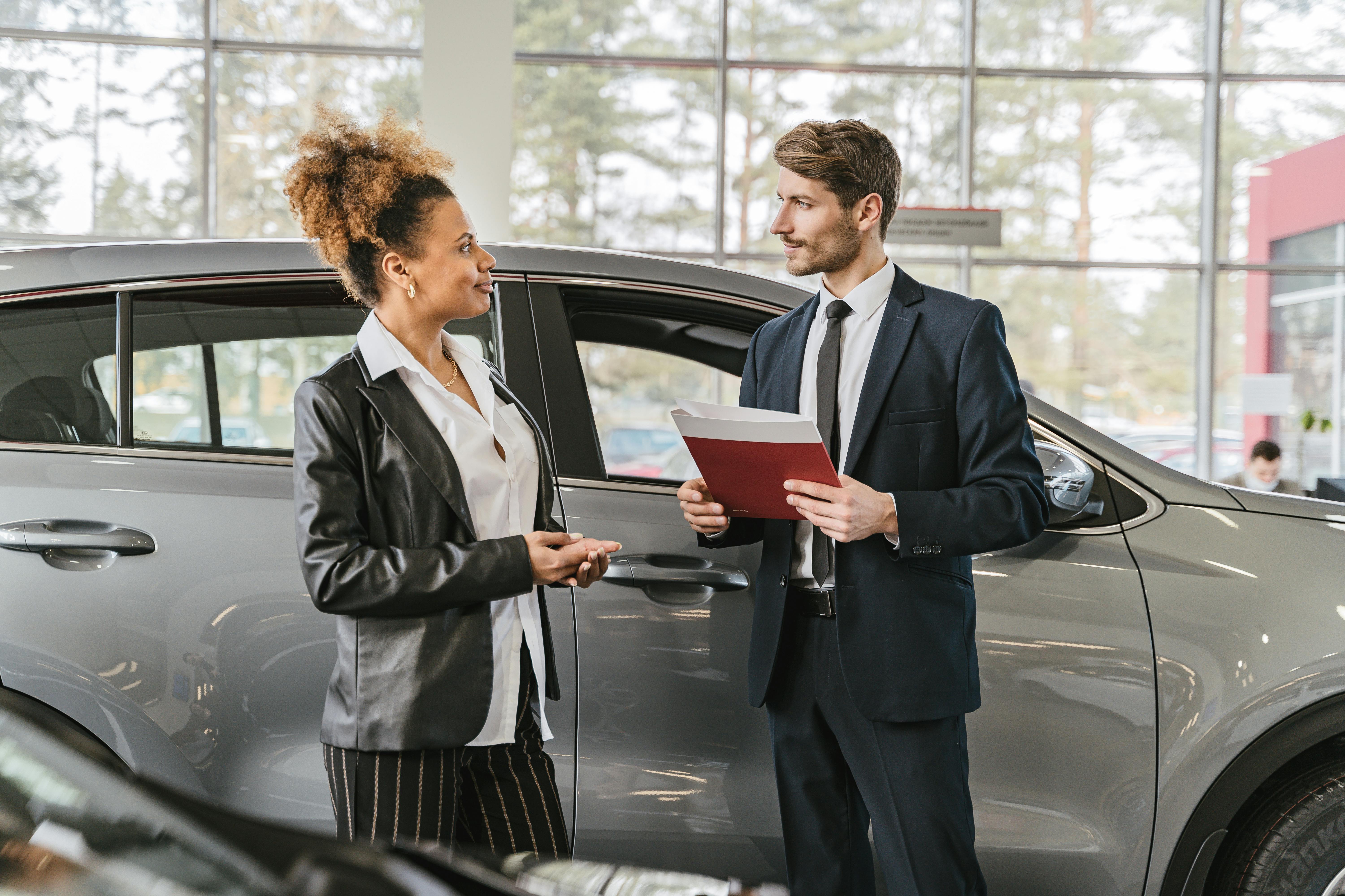 Automobile salesperson showing cars to potential customer